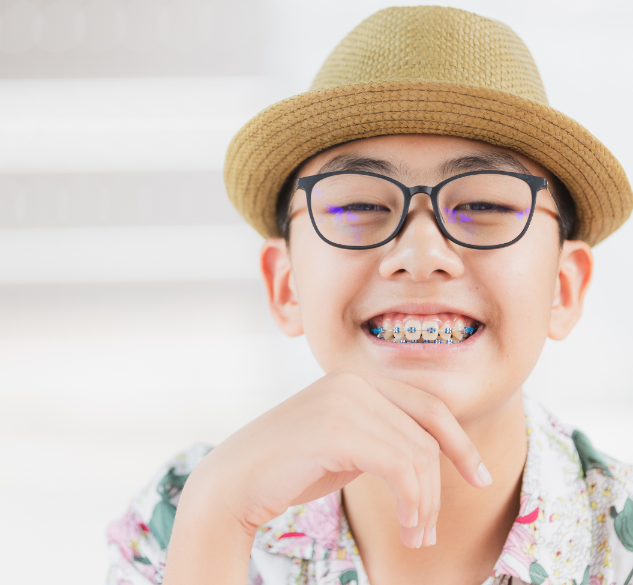 Child with braces wearing straw hat
